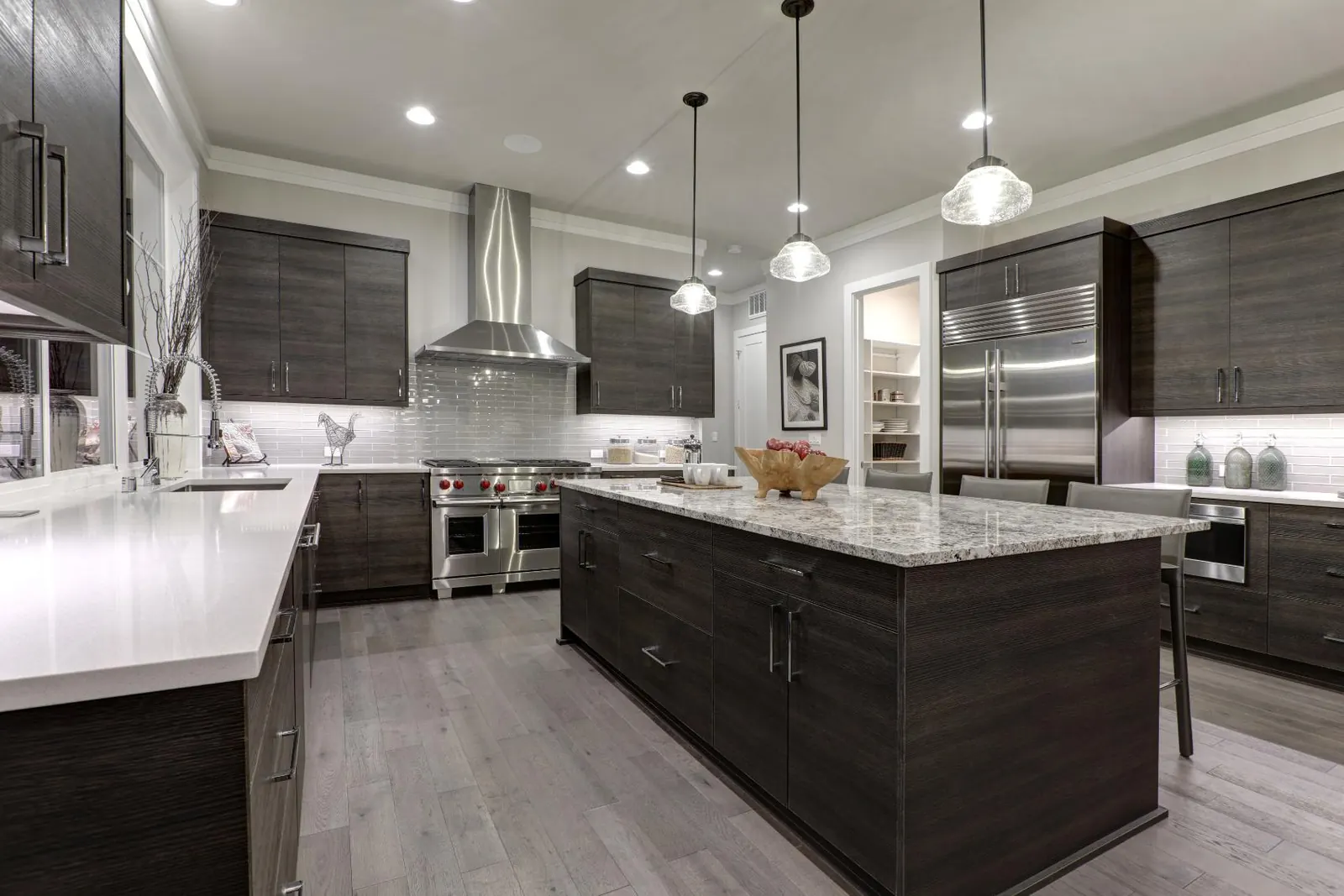 Kitchen with dark wood cabinetry, a light countertop perimeter and a granite island