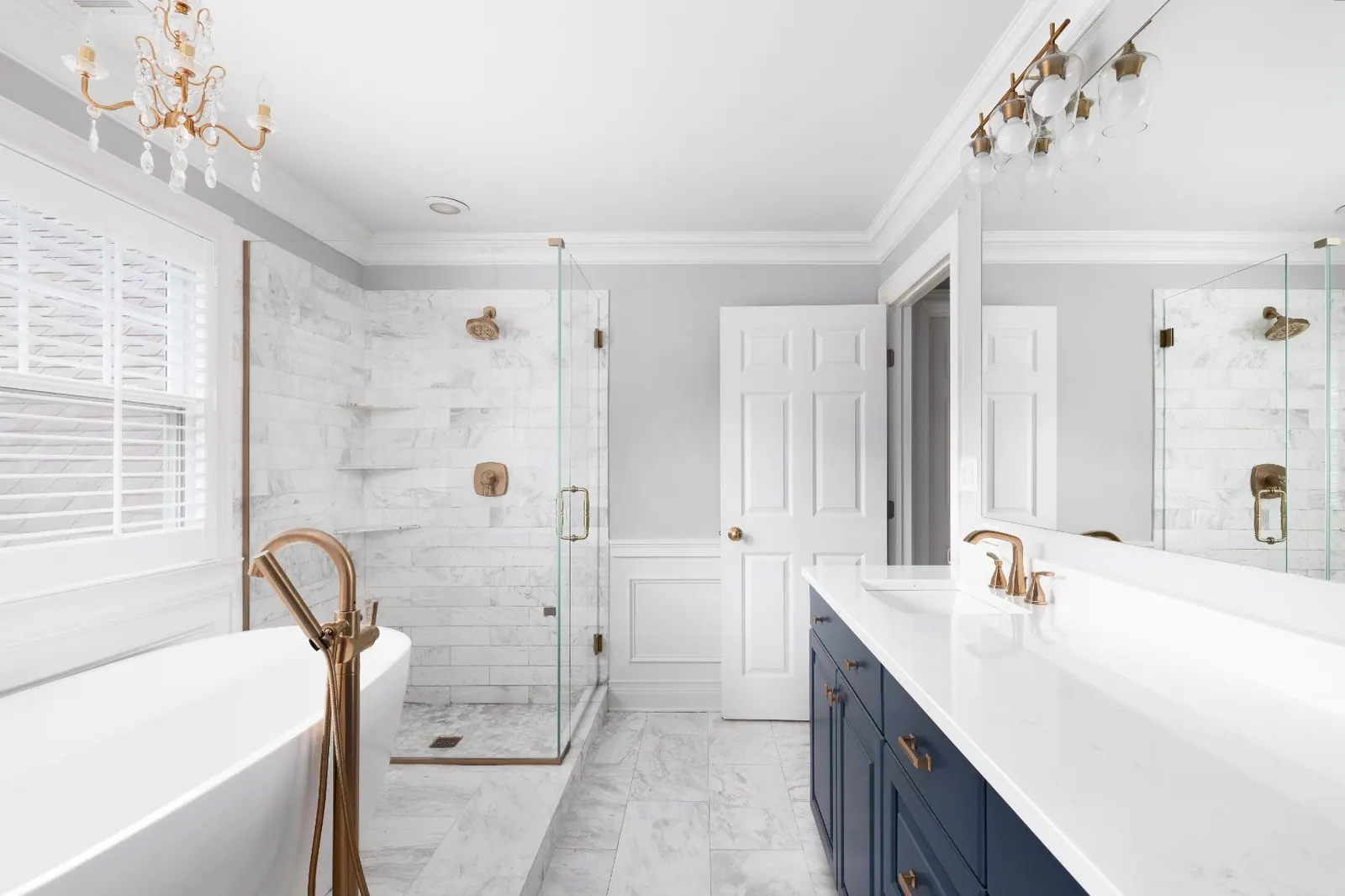 Bright bathroom with a long white vanity countertop on navy cabinets